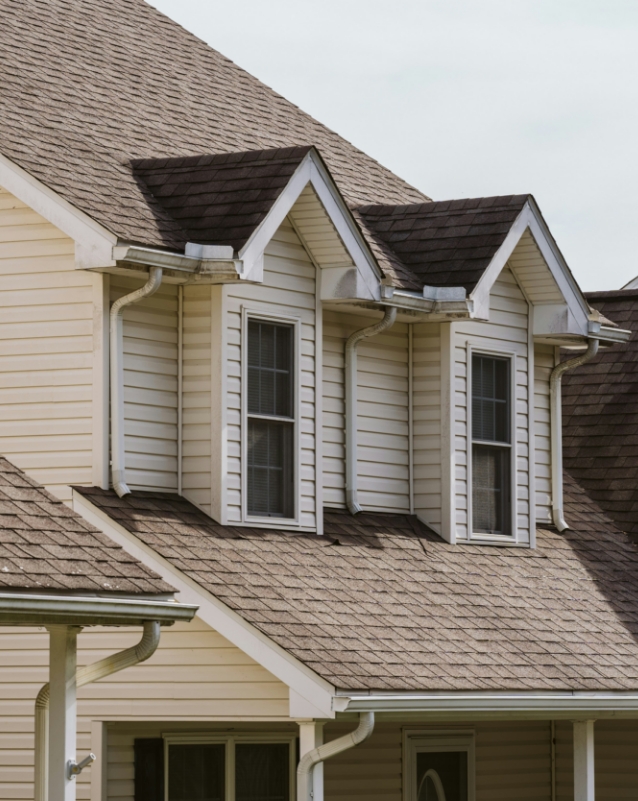 Maison avec toit et fenêtres en saillie.